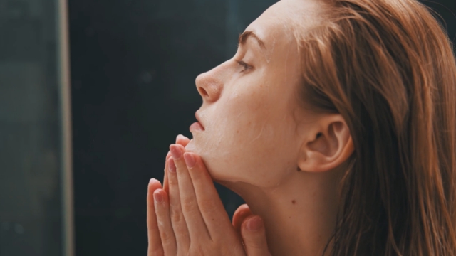 Žena čisti lice pre nanošenja šminke