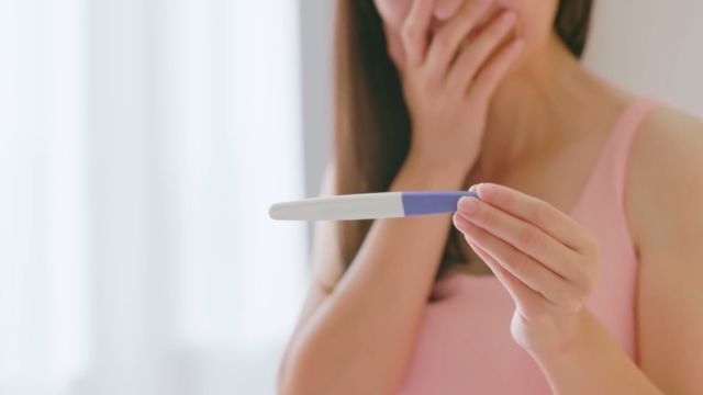 Žena drži test za trudnoću u ruci